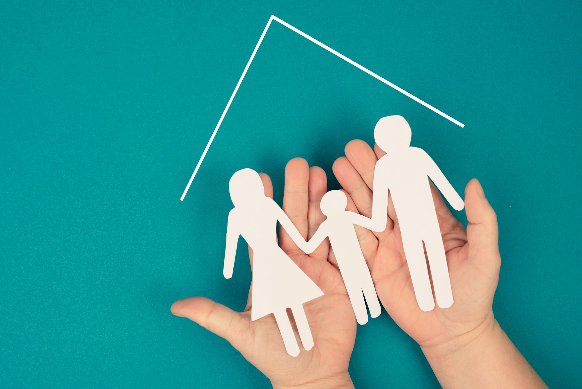 A Family Mother Father And Child In Silhouette Paper Cut Out Holding In Hands.jpg